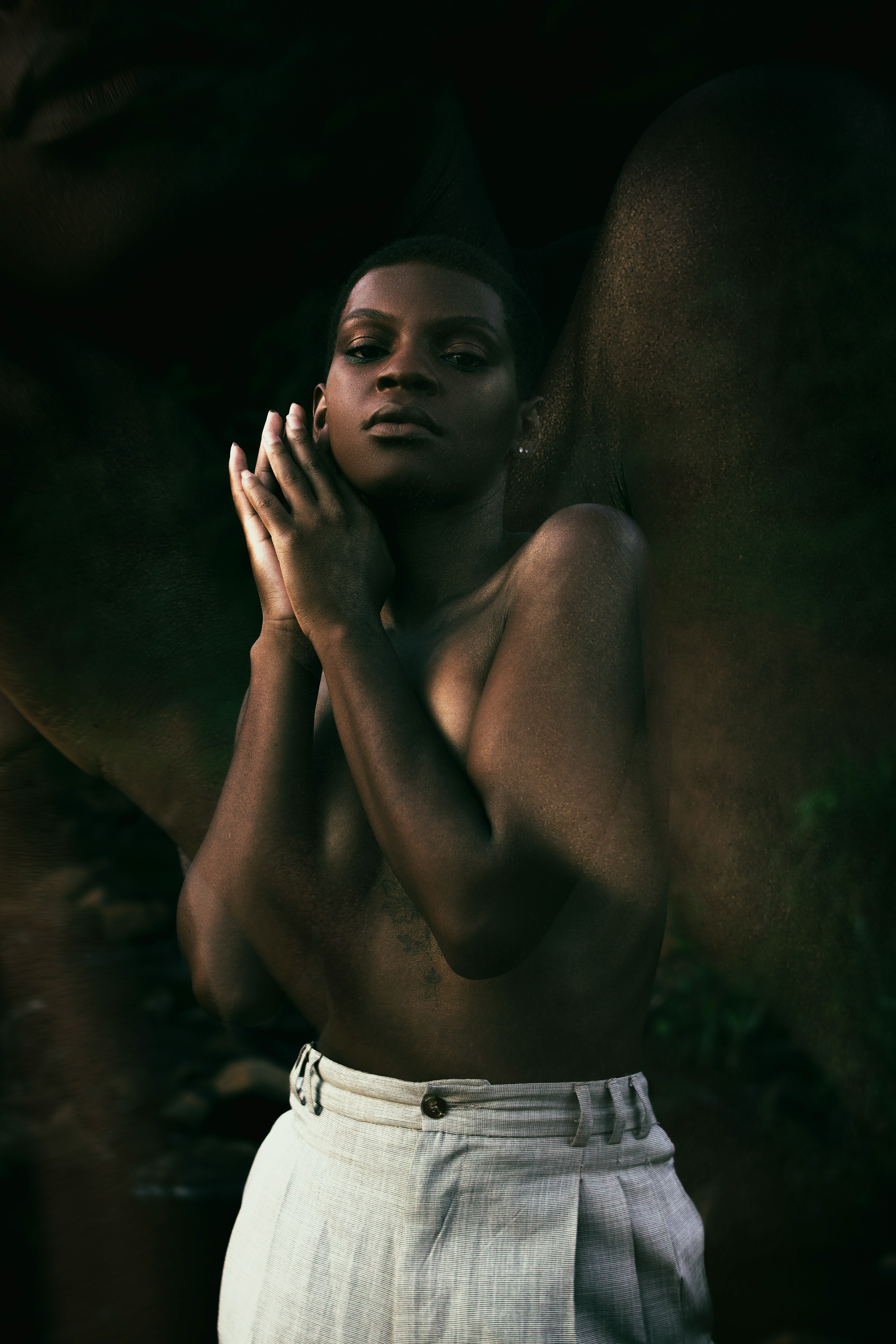 topless woman covering her face with her hands